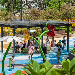 A sheltered sitting-out area is provided adjacent to the water play area, offering seating for parents to keep an eye on their children.